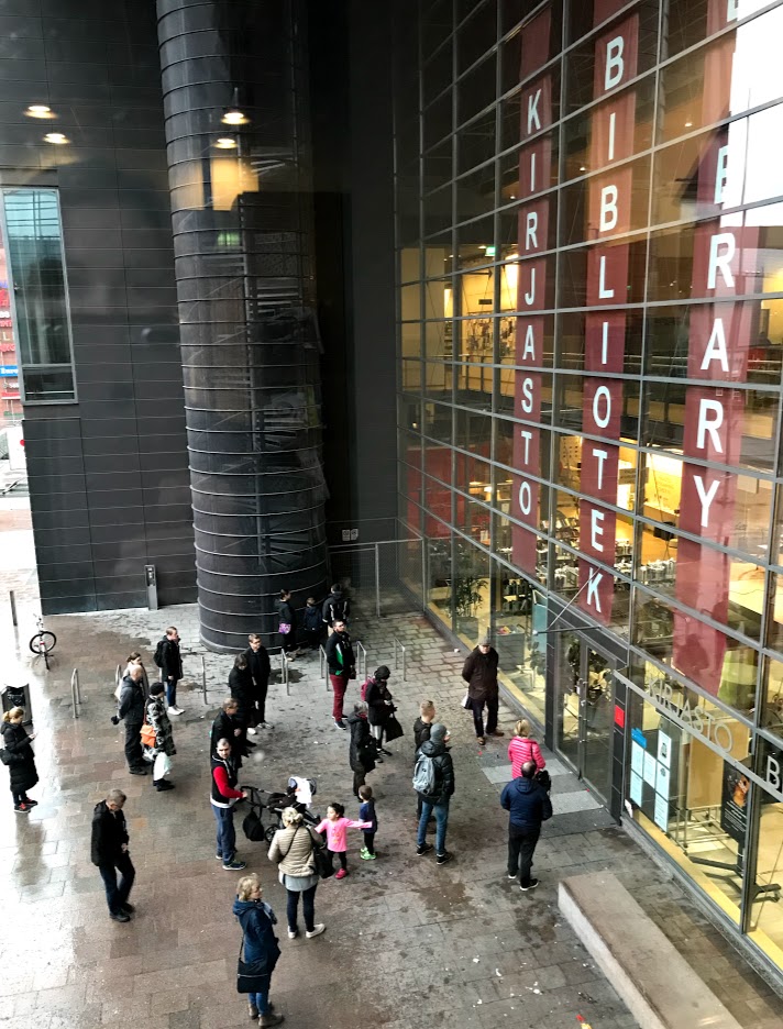 Ihmisiä Sellon kirjaston ulko-oven edessä